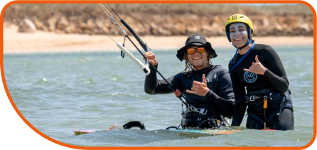 Male holding a kite giving a class to a female beginner kitesurfer