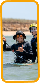 Male holding a kite giving a class to a female beginner kitesurfer