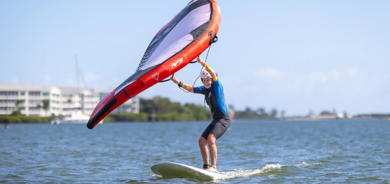 Beginner practicing with a wing foil on flat water in Corralejo, Fuerteventura, Spain, captured in high-definition photo