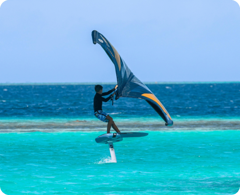 Teenager wing foiling Fuerteventura on flat and blue water