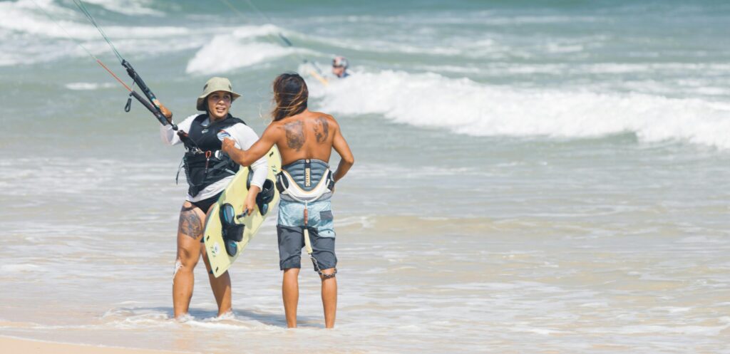 Kitesurfen learnen, Beginner kitesurfers practicing with an instructor on a sunny beach