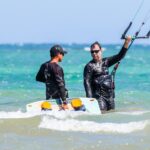 Kitesurfen learnen, Beginner kitesurfers practicing with an instructor on a sunny beach