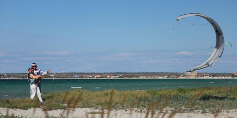 Student learning kite control with an instructor next to him