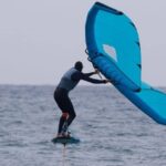 Wing foiler gliding smoothly over the water on a hydrofoil board