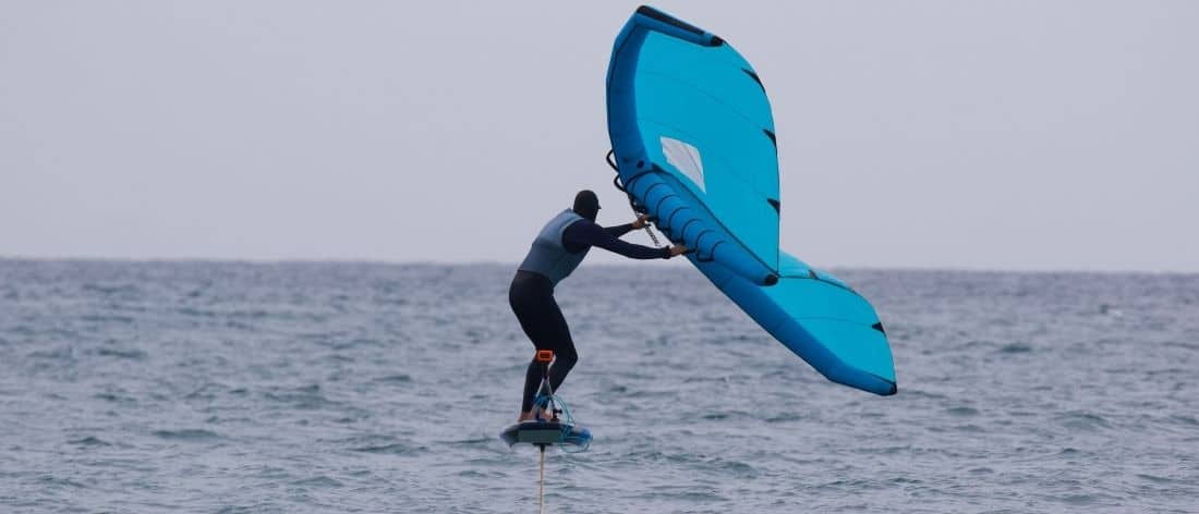 Wing foiler gliding smoothly over the water on a hydrofoil board