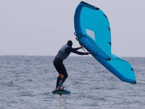 Wing foiler gliding smoothly over the water on a hydrofoil board