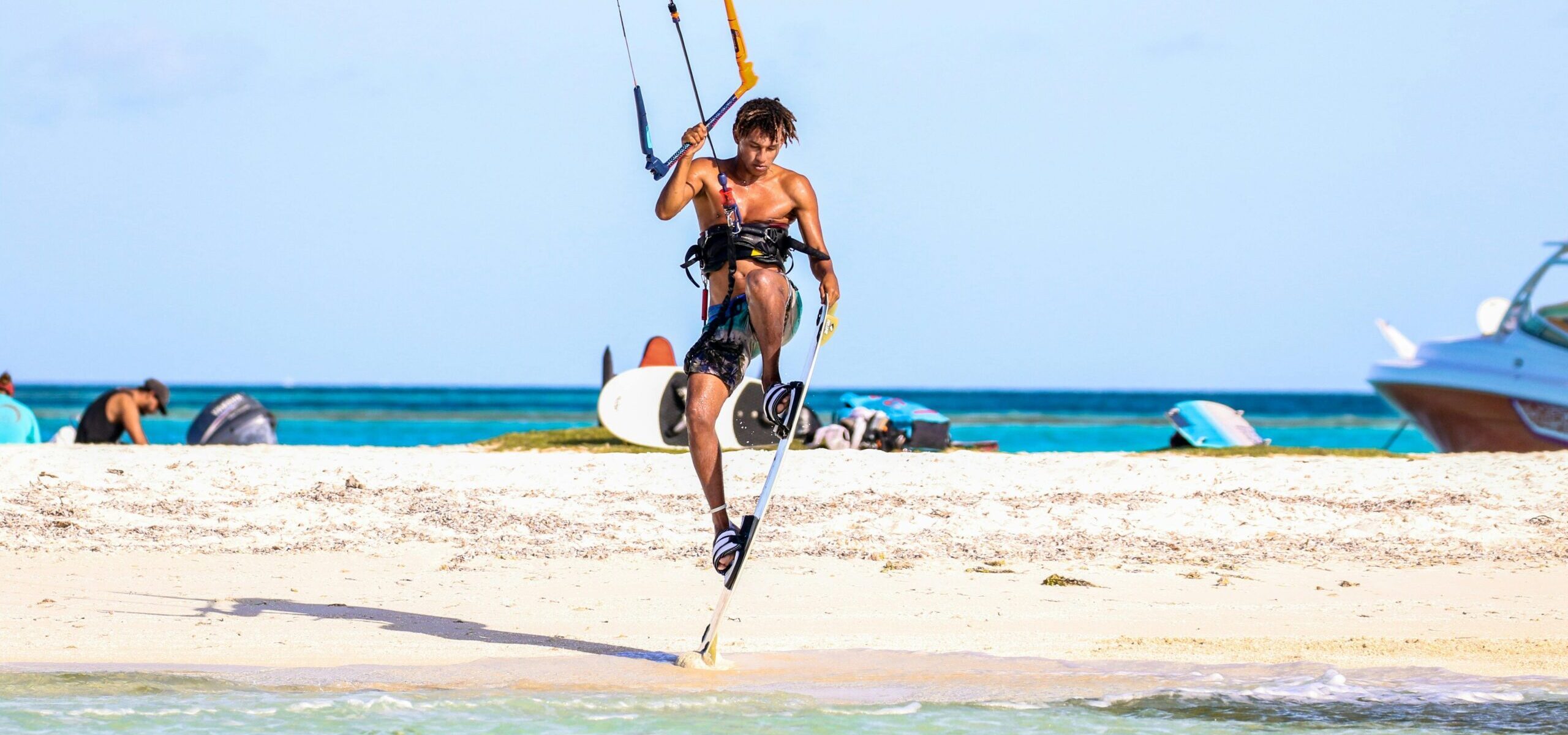 A kiteboarder or kitesurfer performing a trick over flat water