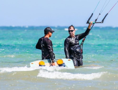 Kitesurfen learnen, Beginner kitesurfers practicing with an instructor on a sunny beach