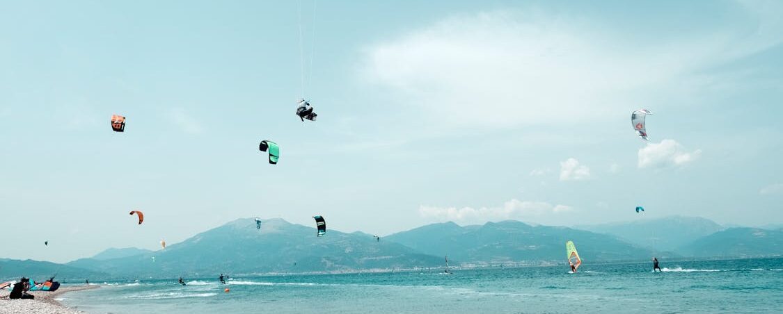 Windsurf and kitesurf coexisting together in the water. A multitude of kiter and windsurfers