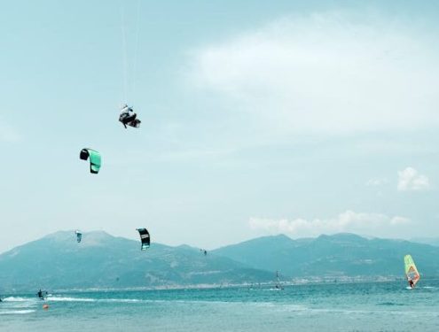 Windsurf and kitesurf coexisting together in the water. A multitude of kiter and windsurfers